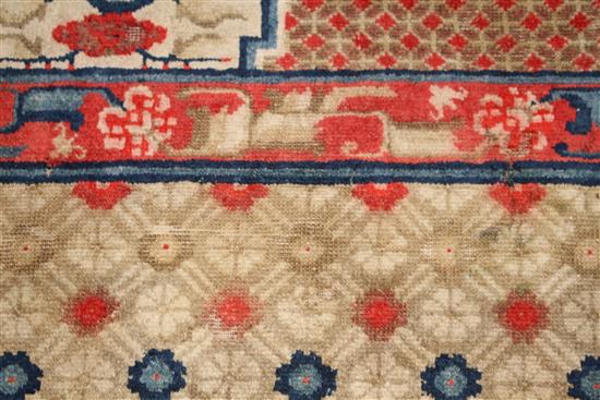 A small Chinese Suiyvan carpet, the fawn ground field woven with a lattice pattern, each cross centred by flowerheads, within a border